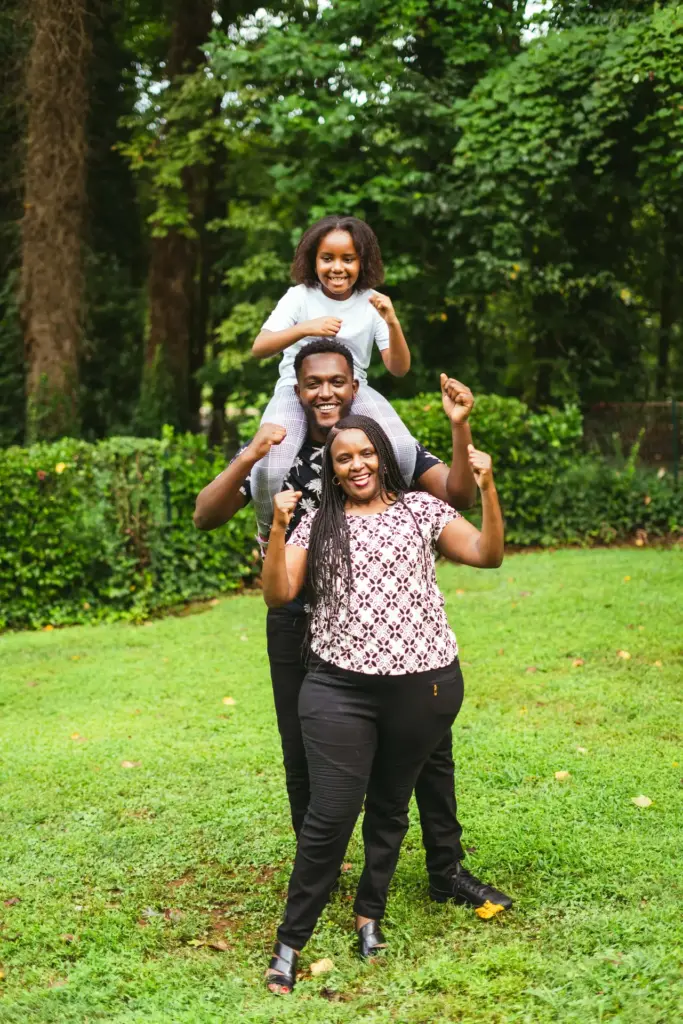family of three posing together in their backyard
