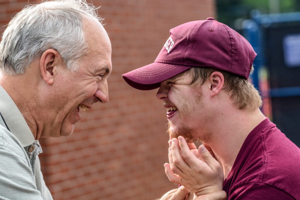 grandfather laughing with his grandson who has down syndrome