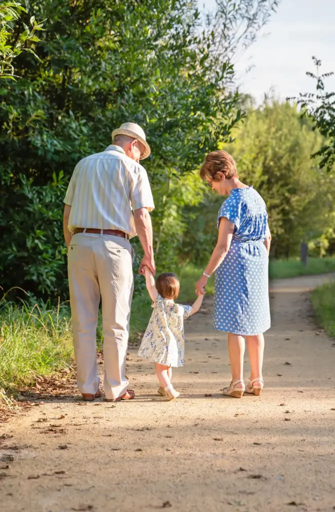 grandparents walking with their young grandchild