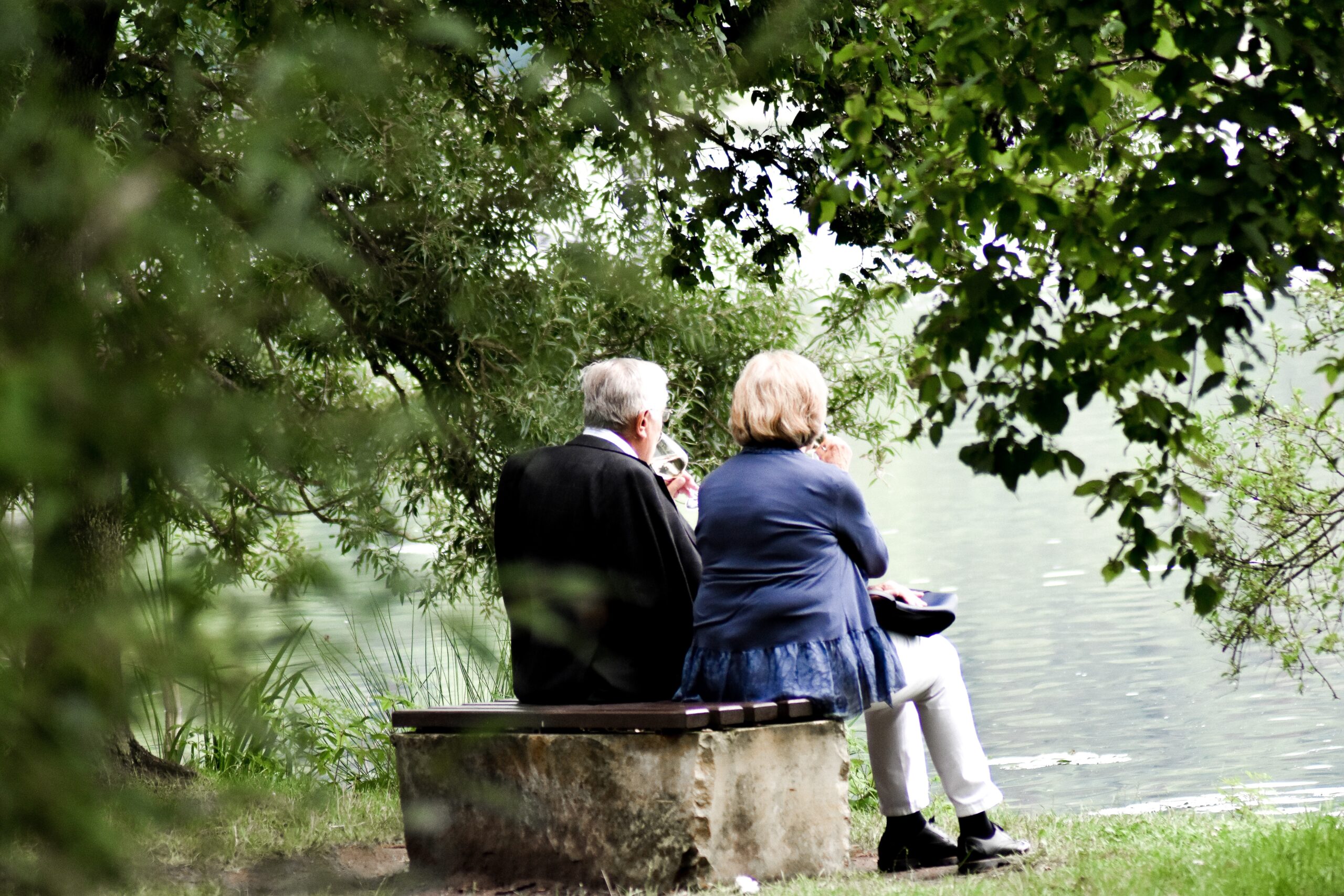 old couple sitting together peacefully by a river