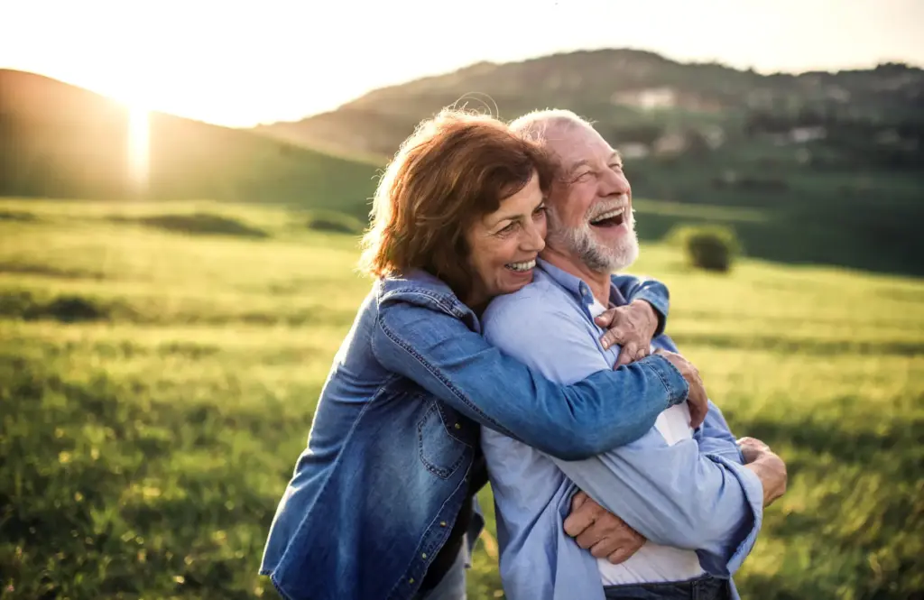 older couple laughing with their arms around each other