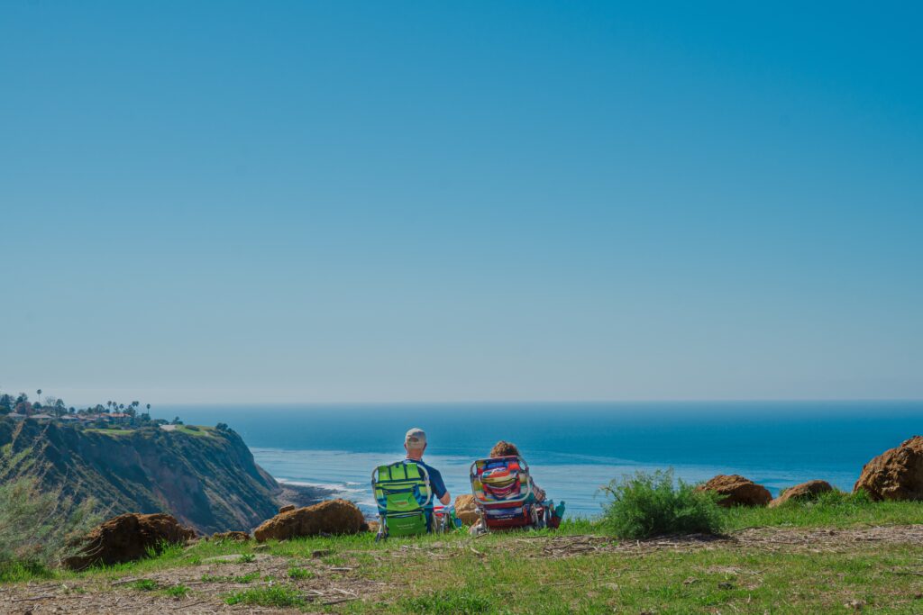 retired couple sitting on beach chairs and viewing the ocean