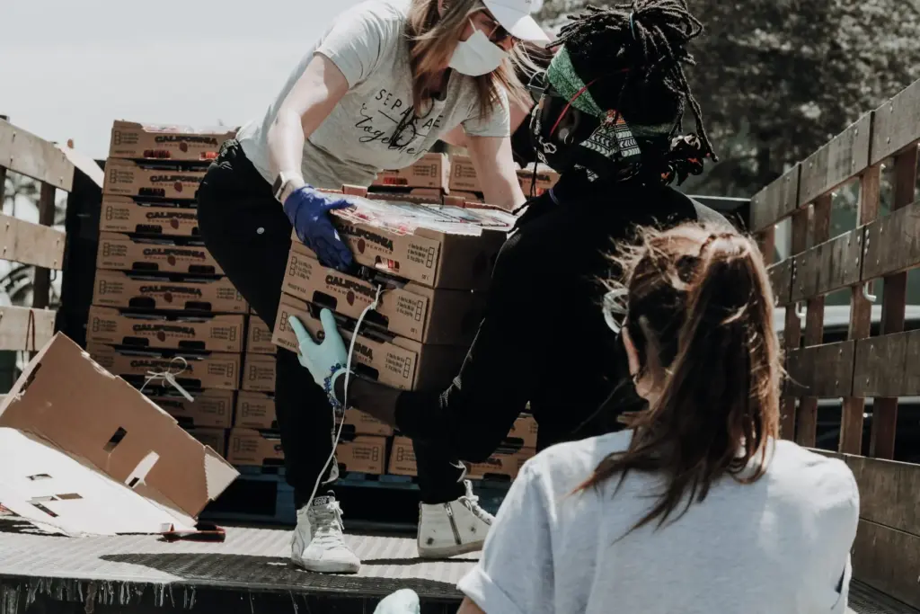 volunteers working together to unload boxes of food