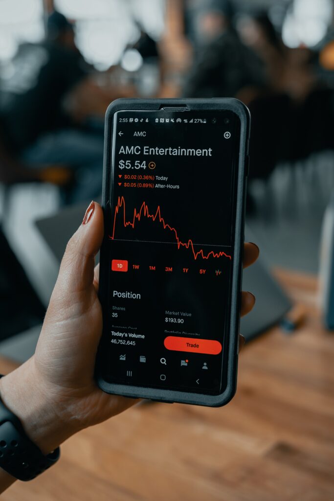 woman holding her phone and looking at stocks
