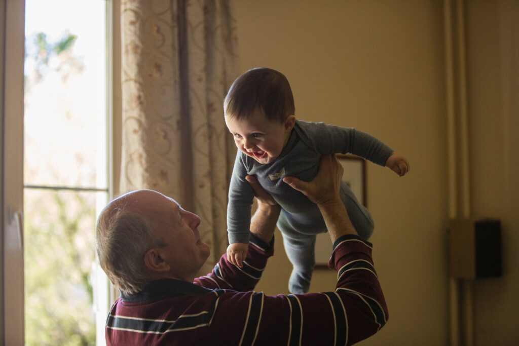 grandfather holding his grandson in the air