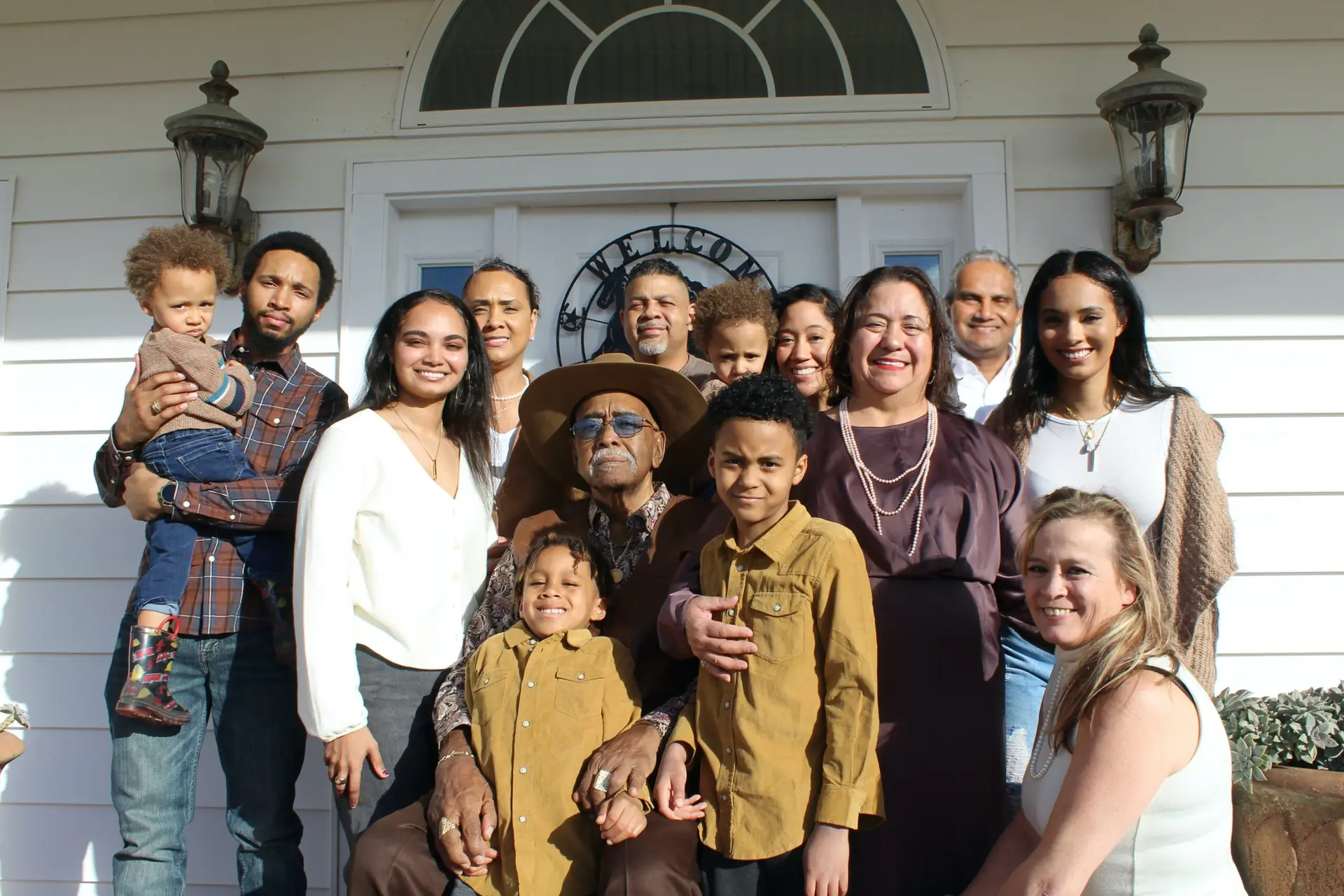 large family gathered together outside a family home