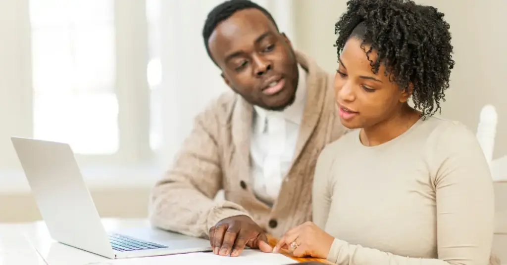 married couple sitting in their kitchen discussing disbursement options
