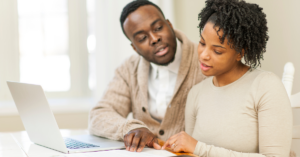 married couple sitting in their kitchen discussing disbursement options