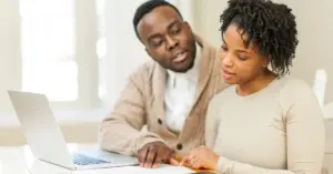 married couple sitting in their kitchen discussing disbursement options